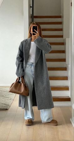 Embrace the season with this casual yet elegant autumn outfit. Featuring a beige long coat, a brown Polène bag, jeans, and Ugg boots, this look is perfect for a stylish day out. #AutumnOutfit #CasualChic #BeigeCoat #PoleneBag #UggBoots #ElegantStyle #FallFashion #OOTD #FashionInspo #StreetStyle Gray Winter Outfits, Hijabi Winter, Vinter Mode Outfits, Winter Date Night Outfits, Thrift Inspo, London Baby, Skandinavian Fashion, Uni Outfits, Cold Outfits