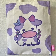 This adorable tote bag has designs on both sides. The front features lavender cow and the back has a plain cow pattern. It's perfect for everyday use! Item Details:♡Heavy Duty 12 oz canvas ♡Pocket with zipper for phone and key ♡Zipper on the top of the bag ♡Length 34 x Height 40 cm ♡Handle 3 x 56 cm ♡Digitally printed front and back designs How to care: Gentle wash with water, please avoid using harsh detergents and soaps. Painting Toat Bag Ideas, Cute Tote Bag Design Paint Aesthetic, Cute Tote Bags Design, Cute Tote Bags Paint, Canvas Bags Painting Ideas, Cute Painted Tote Bags, Toat Bag Painting, Decorating Tote Bags, Painted Tote Bags Ideas