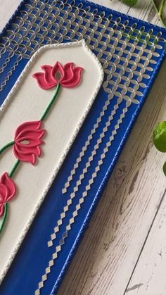 a cake decorated with red flowers on a blue and white tray next to green leaves