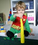 a young boy playing with toys in his playroom