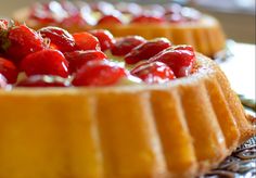 there are many desserts on the table and one is topped with strawberries or raspberries