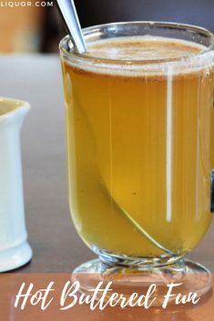 hot buttered fudge in a glass mug with a spoon sticking out of it