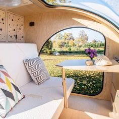 the inside of a camper with a couch and table in it's center