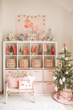 a christmas tree is in front of a shelf with baskets and other decorations on it