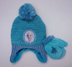 a knitted hat and mittens with a frozen princess picture on the front in blue