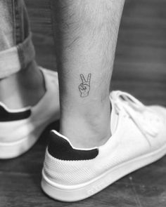 a person's foot with a small tattoo on their left ankle and the word peace written