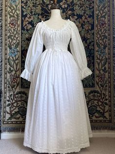 A Historically inspired white 100% cotton smocked chemise dress with bishop bell sleeves is pictured on a mannequin in front of an ornate tapestry background. Smocked Chemise, Chemise Dress, Medieval Fashion, Stunning Gowns, Edwardian Fashion, Baroque Fashion, Cotton Lace, Full Skirt, Victorian Fashion