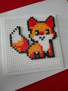 a beaded picture of a fox on a white surface