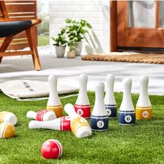 several bowling pins and balls on the grass