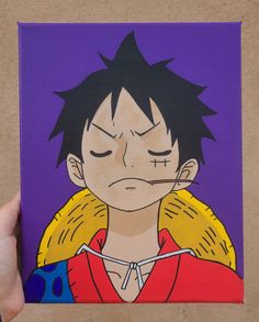 a hand holding up a painting of an anime character with eyes closed and tongue out