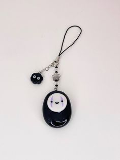 a black and white key chain with a cartoon face on it, hanging from a lanyard