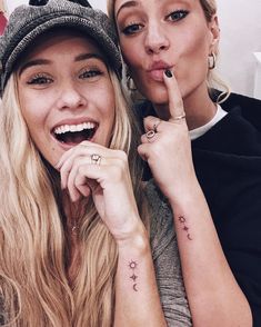 two beautiful women posing for the camera with their fingers on their lips and one holding her finger up to her mouth