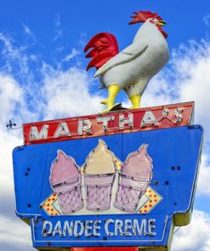 a large sign with a rooster on top of it's head and the words martha's dandee creme