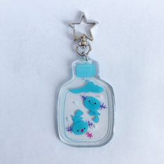 a bottle shaped keychain with two blue birds on it and a star in the background