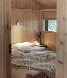 a bed in a room with wooden walls