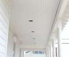 an empty hallway with white walls and columns