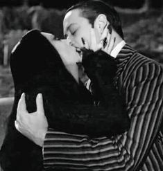 black and white photograph of a man kissing a woman