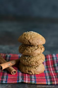 three cookies stacked on top of each other with cinnamon sticks next to them in the foreground