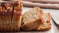 two pieces of bread sitting on top of a piece of paper next to a knife