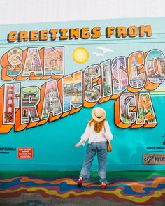 a woman standing in front of a colorful wall with the words san francisco on it