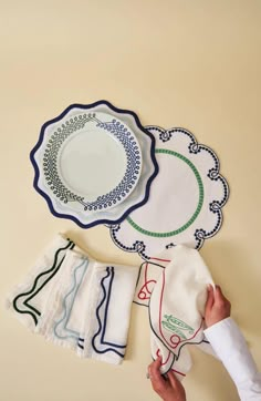 a person holding napkins and plates on top of a table