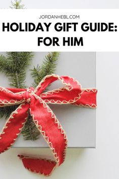 the holiday gift guide for him is on top of a white box with red ribbon