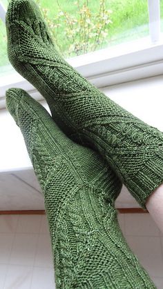 a person wearing green knitted gloves and socks