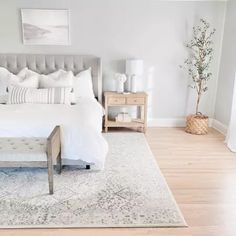 a bedroom with a large bed and white linens on the floor, along with two nightstands