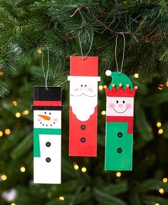 three christmas ornaments hanging from a tree with lights in the background and snowmen on them