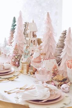 a table set for christmas with pink and gold decorations