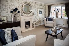 a living room filled with furniture and a fire place in front of a mirror on the wall