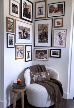 a white chair sitting in front of a wall with pictures on it's walls