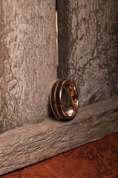 two wedding rings sitting on the edge of a wooden door