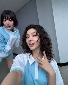 two young women posing in front of a mirror