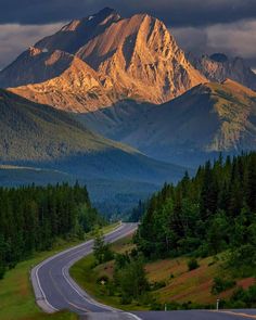 an empty road in the middle of a mountain range