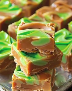 several pieces of candy sitting on top of a metal tray covered in green and brown swirled icing