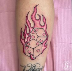 a woman's leg with a tattoo on it that has flames and hearts in the shape of cubes