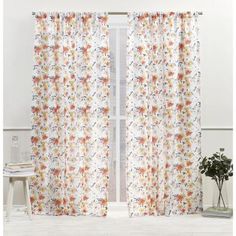 a white curtain with flowers on it in front of a window and a potted plant