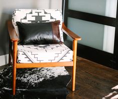 a chair with black and white pillows on it