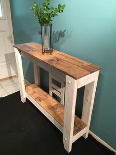 a wooden table sitting next to a wall with a potted plant on top of it