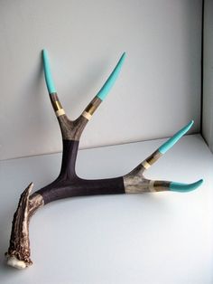 the antler is made out of wood and has two different colored sticks sticking out of it