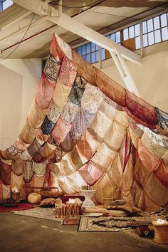 a large pile of fabric sitting on top of a floor next to a tall window