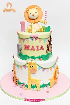 a baby's first birthday cake with a lion and giraffe on top