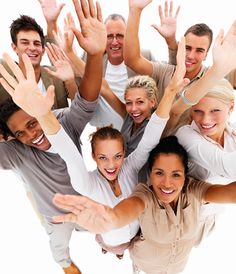 a group of people standing together with their hands up in the air and smiling at the camera