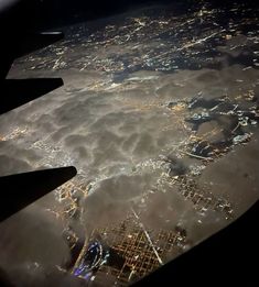 an aerial view of the city lights and clouds at night as seen from space shuttle