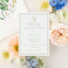 the wedding stationery is surrounded by flowers