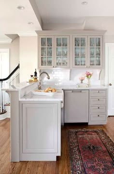 a kitchen with white cabinets and wooden floors