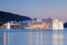 a large white building sitting on top of a lake