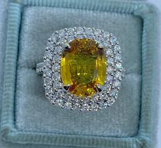 a fancy yellow diamond ring in a box