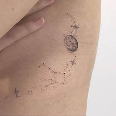 a woman's stomach with stars and a clock tattoo on her left side ribcage